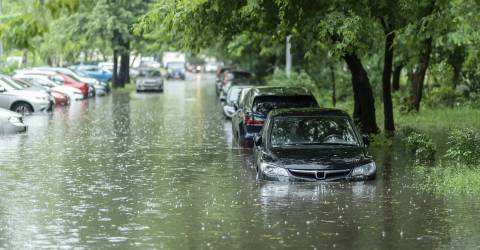Een straat die onderwater is gelopen met allerlei auto's die onder water staan